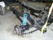 1992 Ford Bronco - The chassis of a 1992 Ford Bronco is shown with its front suspension components, including bright blue coil springs.