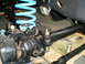 1992 Ford Bronco - This image shows the front suspension components of a vehicle, including a bright blue coil spring.
