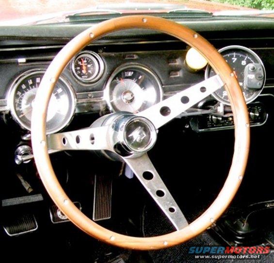 1967 Mercury Cougar interior showing wood steering wheel, tachometer, speedometer, and temp gauge