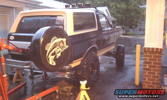 Ford Bronco rear view with spare tire cover a bass fish graphic. Lifted suspension visible
