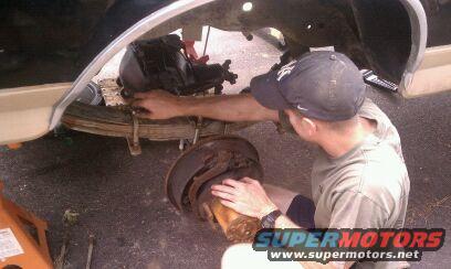 guy working on rear axle brake drum