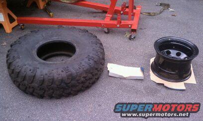 Large off-road tire and black steel wheel on asphalt