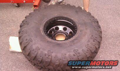 Large off-road tire and wheel with Supermotors.net logo