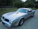1976 Pontiac Trans Am - This silver 1976 Pontiac Trans Am features a distinctive hood scoop and fender vents, characteristic of the model year.