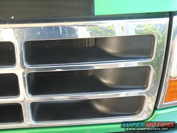 Green Ford Bronco grille with chrome accents, close-up view