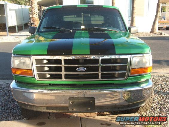 Green Ford truck with black racing stripes on the hood and roof