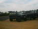 1988 Ford Bronco - A black Jeep Cherokee XJ is parked on a dirt lot next to a black pickup truck under a cloudy sky.