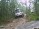 1988 Ford Bronco - A 1988 Ford Bronco navigates a rocky, wooded trail during an off-road excursion.