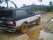 1988 Ford Bronco - This two-tone Ford Bronco navigates a challenging muddy terrain, its off-road capabilities.