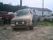 1988 Ford Bronco - A tan Ford Bronco is shown from the front, covered in mud, with a red Toyota truck in the background.
