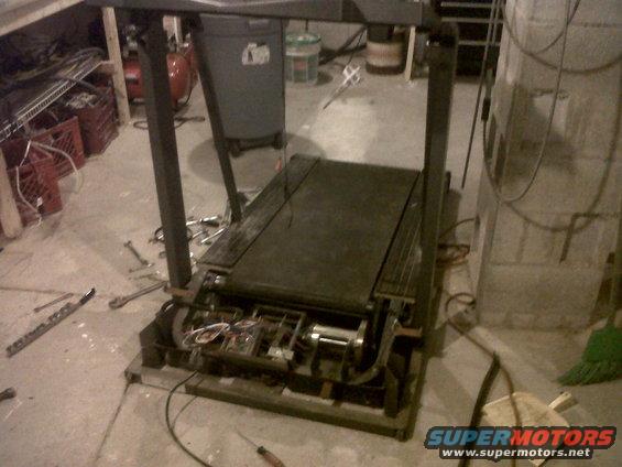 Treadmill motor and belt assembly with tools scattered around