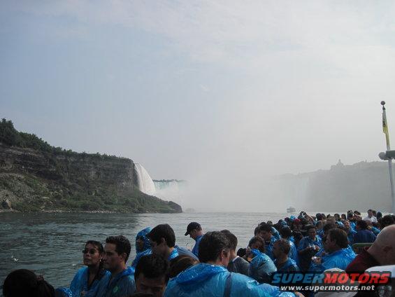 People in blue ponchos on a boat looking at Niagara Falls