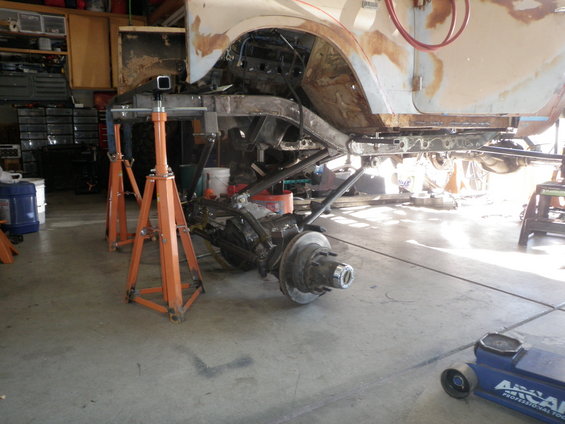 Vehicle chassis on jack stands, showing suspension and frame