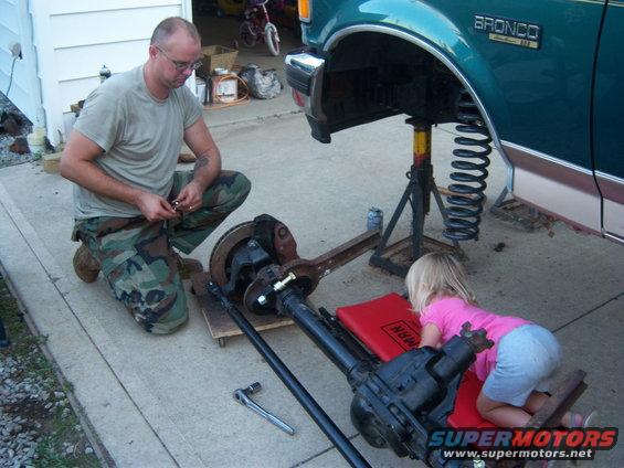 1996 Ford Bronco side view, man working on suspension with child