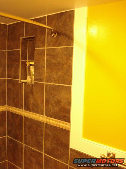 014.jpg not the best pic, but there is a recessed shelf built into the shower using the same tile as the shower itself