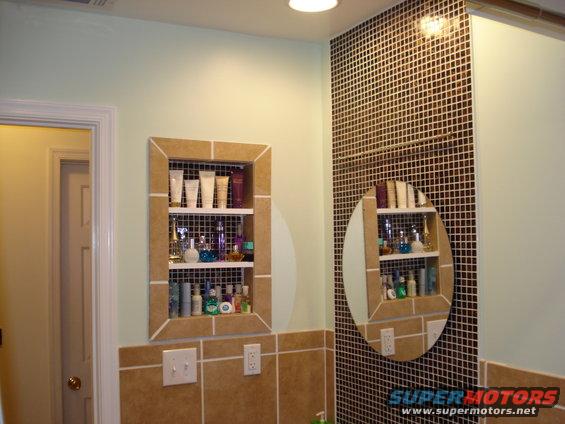 mosaic tile used for backing the mirror and backing in the recessed open med cab