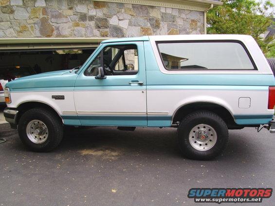 Two-tone teal and white Ford Bronco parked in driveway