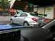 2007 Subaru Impreza - Silver sedan with a large rear spoiler and racing stripes is parked on a city street.