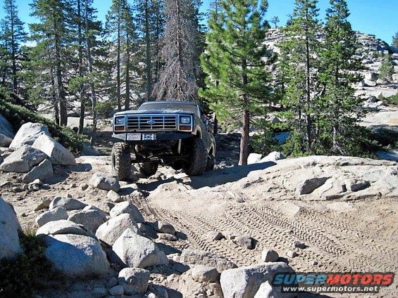 Dark blue lifted Ford Bronco on rocky trail