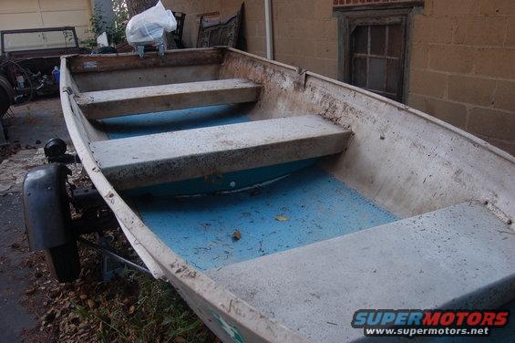 Aluminum boat with blue interior and two gray benches, on a trailer