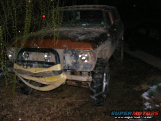 1978 Ford Bronco front view, mud-covered with winch strap