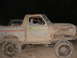 1978 Ford Bronco - A woman sits in the driver's seat of a heavily muddied 1978 Ford Bronco.