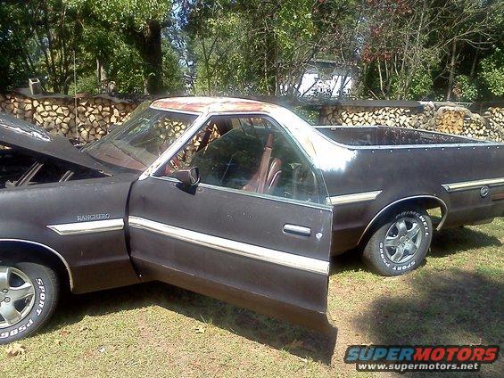 Dark brown 1979 Ford Ranchero with hood and driver door open, parked outside