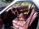 1979 Ford Ranchero - The interior of a vehicle features maroon upholstery with a distinctive patterned design on the seats and a red steering wheel.