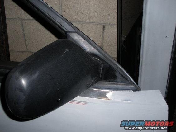 Black car door mirror on a white vehicle
