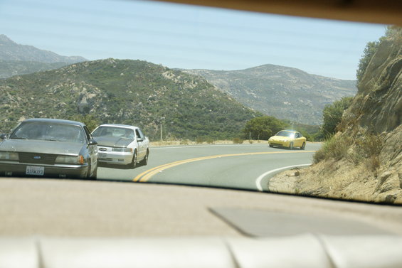 Gray 1995 Ford Taurus front view on a mountain road with two other cars