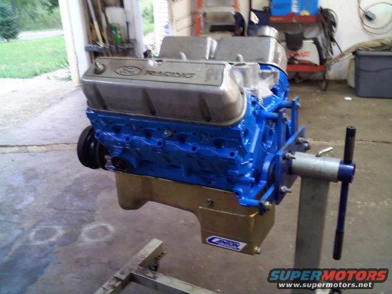Blue Ford Racing V8 engine on a stand in a garage