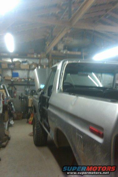 Silver 1978 Ford Bronco in a garage, hood open, undergoing repairs
