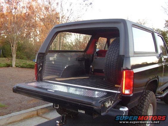 Ford Bronco rear cargo area with diamond plate lining and tailgate down. Spare tire mounted inside