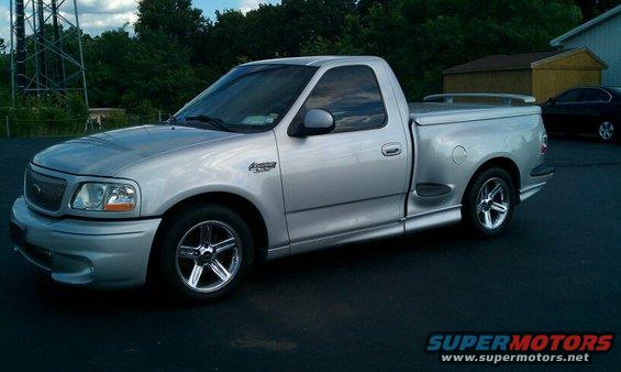 Silver pickup truck with a bed cover, seen from the front three-quarter angle