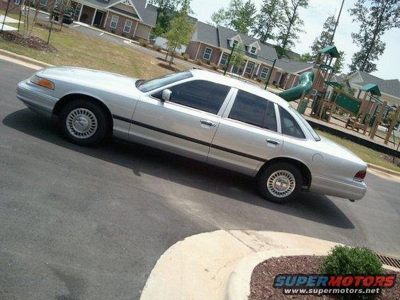 Silver 1997 Ford Crown Victoria parked on street, side view