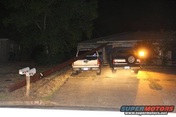 Black Ford Bronco with spare tire on rear, parked at night