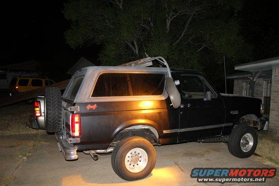 1993 Ford Bronco parked at night, side view. The spare tire is mounted on the rear door