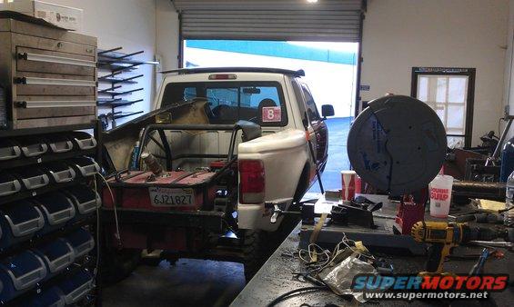 1992 Ford Ranger pickup truck with a custom bed setup, parked inside a workshop