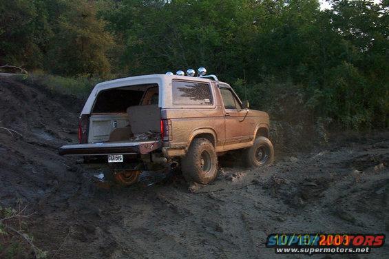 1982 Ford Bronco with tailgate down on muddy terrain