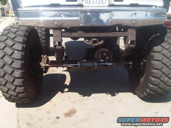 Rear axle and large tires of a modified truck with a chrome bumper and trailer hitch