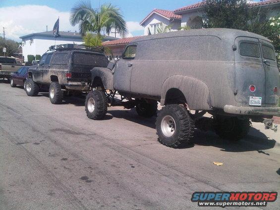 Panel van with lifted suspension and oversized tires, towing a lifted SUV