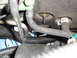 2003 Ford Taurus - Close-up view of automotive AC lines and a wiring harness, with a mechanic's gloved hands present.