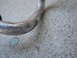 2003 Ford Taurus - A close-up view of a damaged metal pipe on a concrete surface.