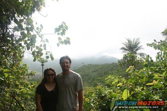 Couple posing in front of a misty mountain landscape with dense foliage