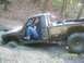 1989 Ford Bronco - A driver navigates a muddy trail in a heavily modified off-road truck.