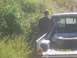 1989 Ford Bronco - A man stands next to the bed of a pickup truck, with a spare tire visible inside.