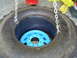 1992 Ford Bronco - A large tire is shown with a blue wheel inside, held up by chains.