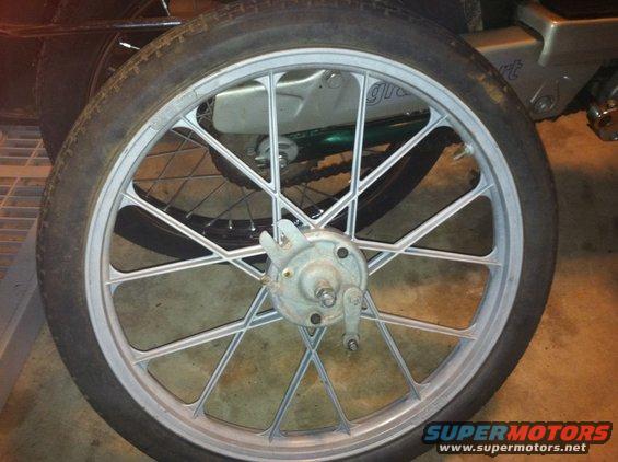 Close-up of a spoked motorcycle wheel with a drum brake assembly