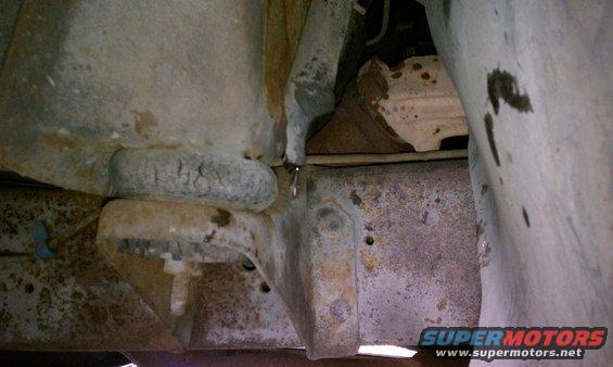 Close-up of heavily rusted frame rails and suspension parts on an old vehicle