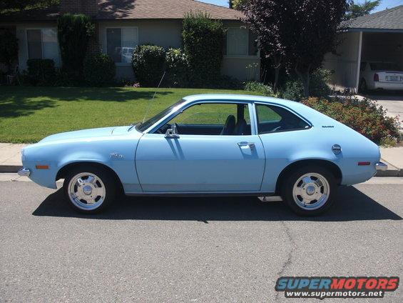 Light blue 1972 Ford Pinto coupe parked on a residential street, side view